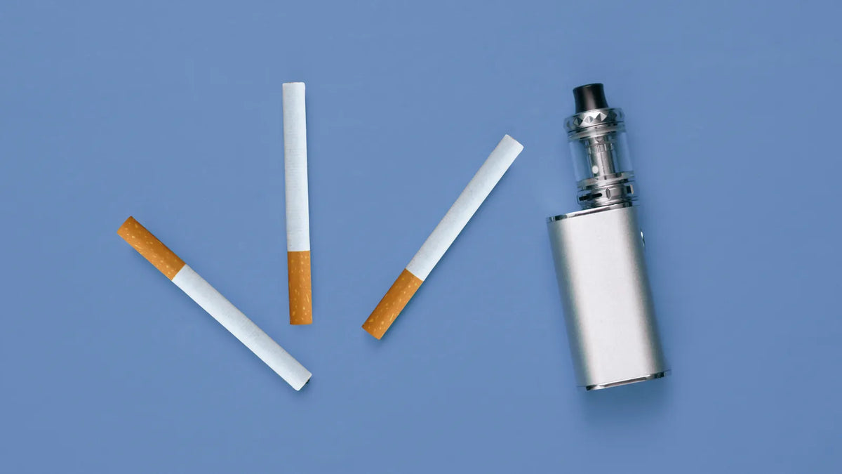 une cigarette électronique présentée à côté de cigarettes de tabac