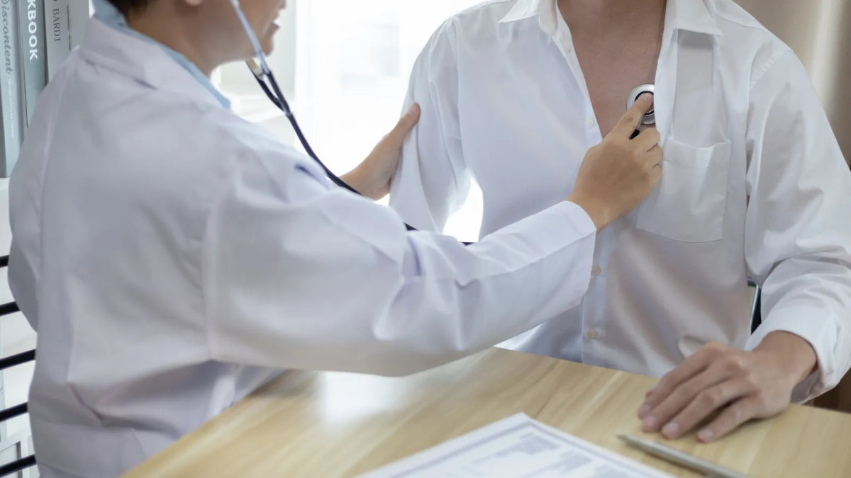 Un patient en consultation avec un médecin qui écoute avec un stéthoscope au niveau du torse