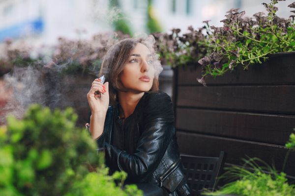 Femme vapotant avec sa cigarette électronique